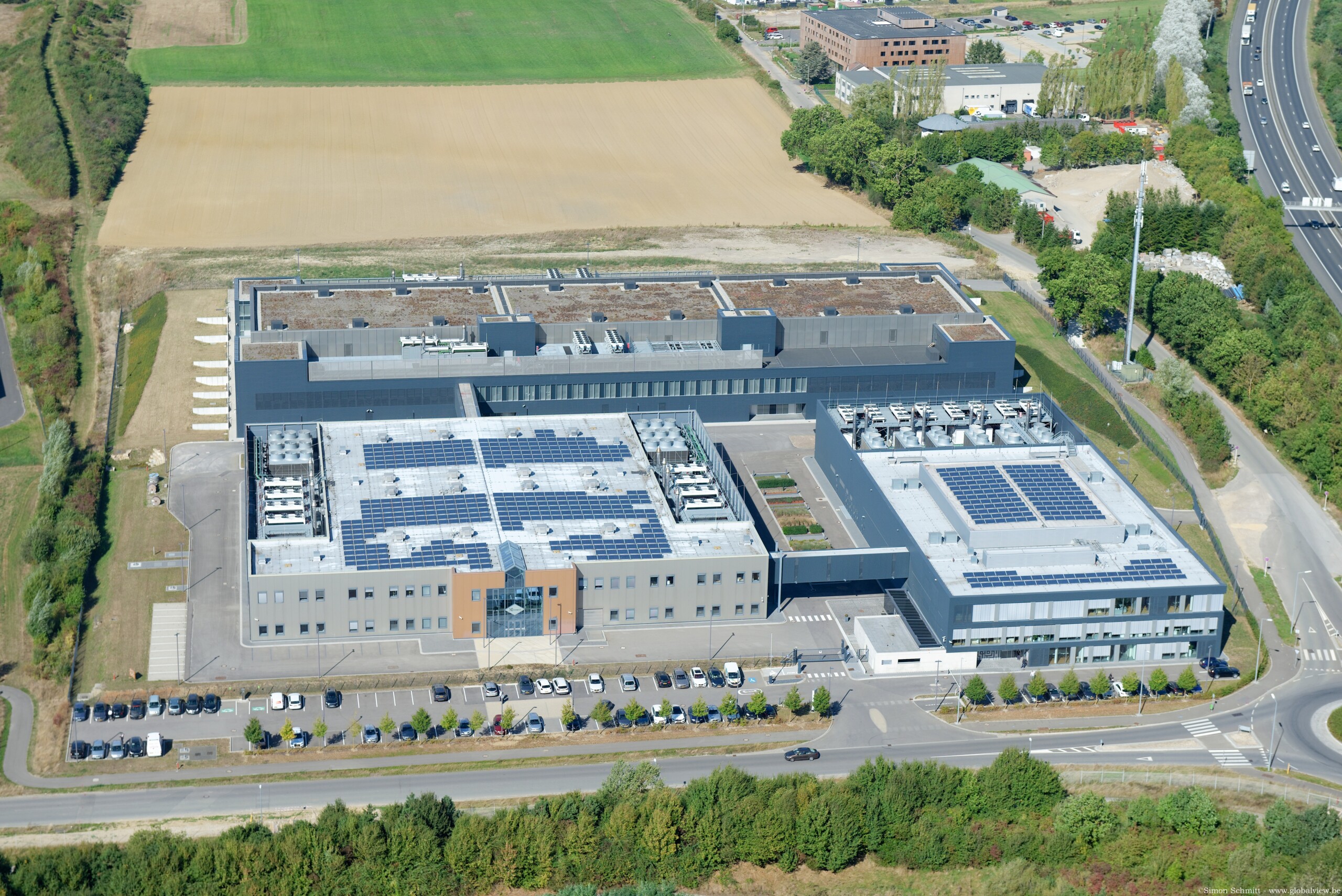 Le site de Bettembourg rassemble le siège de la société et 3 data centres.  Le terrain adjacent va bientôt accueillir un nouveau bâtiment administratif (crédit Schmitt-GlobalView)
