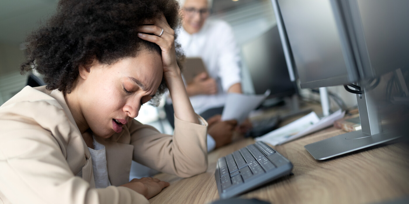 Une employée se tient la tête devant son ordinateur