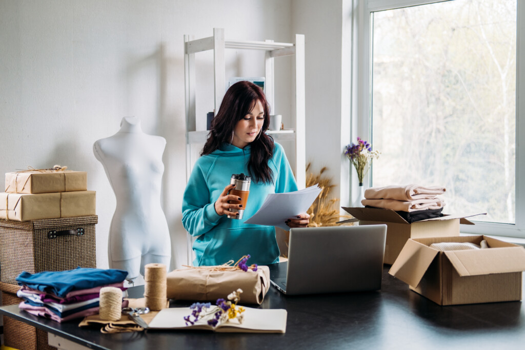 Jeune créatrice de mode travaillant dans son atelier, vérifiant les commandes.