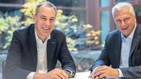 Siemens and Capgemini deepen partnership: (from left) Cedrik Neike, CEO of Digital Industries and Member of the Managing Board of Siemens AG and Aiman Ezzat, CEO of the Capgemini Group (Source: Siemens AG) 2 hommes assis à table, les mains croisées une sur l'autre.