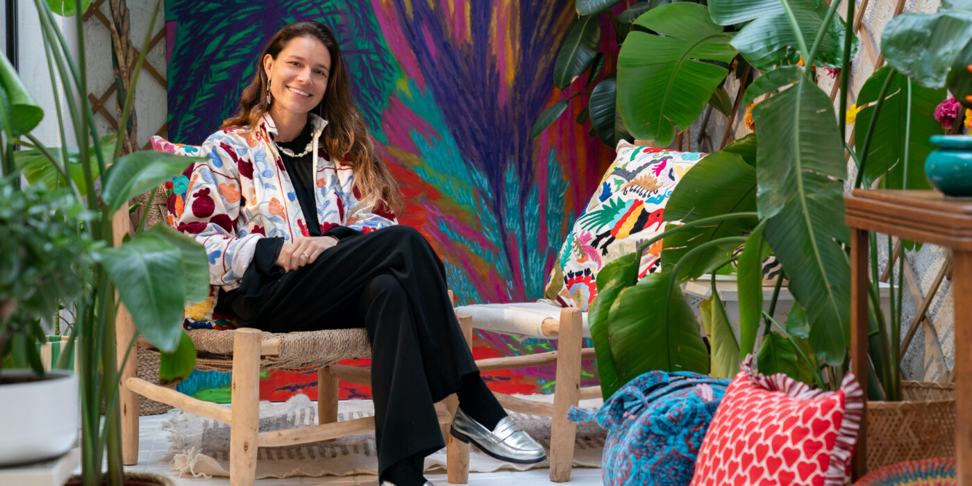 Debbie Kirch assise dans le jardin d'hiver de son magasin Devï