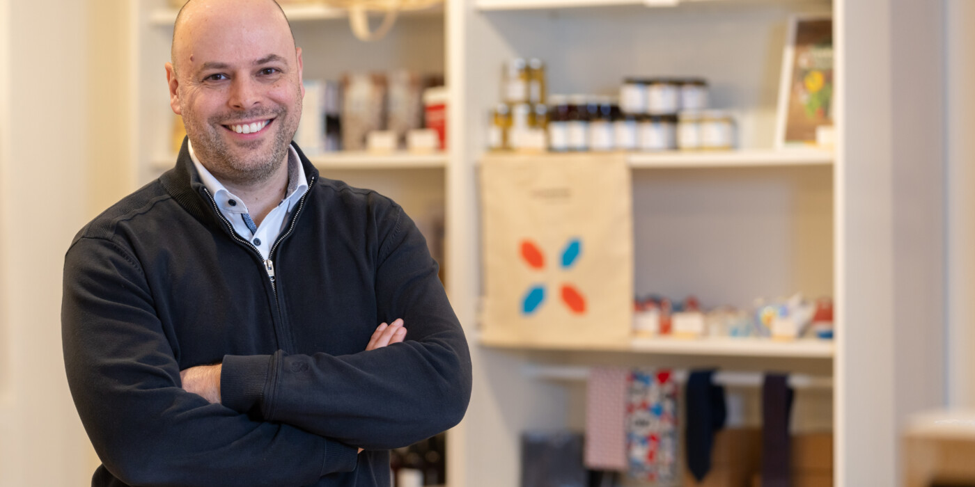 Marc Ewert devant des étagères de produits Luxembourg - Let’s make it happen, dans la Luxembourg House.