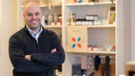 Marc Ewert devant des étagères de produits Luxembourg - Let’s make it happen, dans la Luxembourg House.