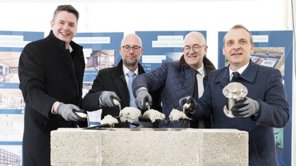 Luxconnect, Pose de la première pierre, Photo: Ann Sophie Lindström 4 hommes mettent du ciment sur un mur