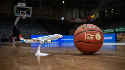 Ballon de basket et avion mignature sur un terrain de basket