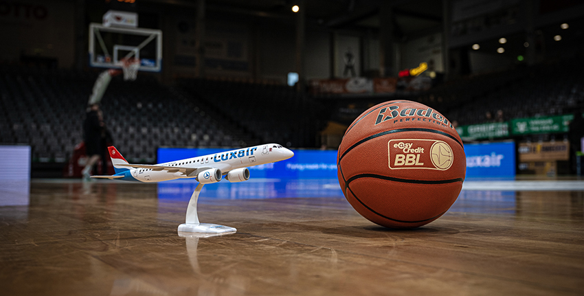 Ballon de basket et avion mignature sur un terrain de basket