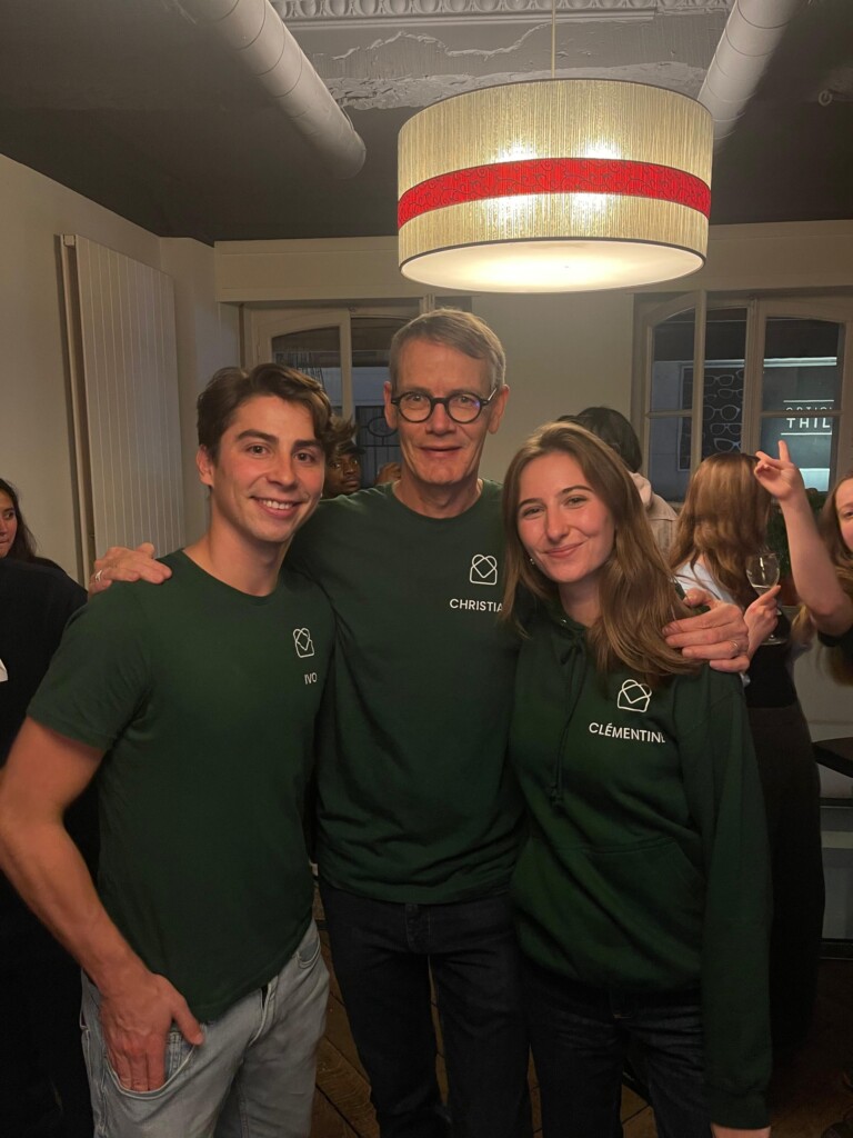 Les deux fondateurs de la société ainsi que leur coach se tiennent par les bras