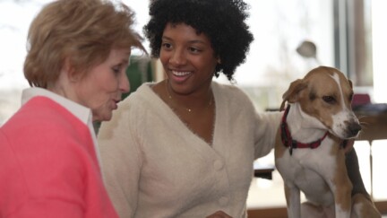 Chez WeConnect, les cohabitations tissent très souvent un lien fort entre l'hôte et son locataire (crédit : WeConnect) Une dame âgée et une jeune étudiante qui caresse un chien.