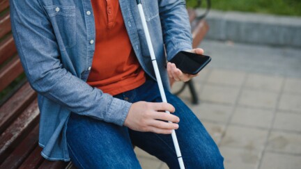 (crédit: Envato) Young blinded man using phone and sending voice message.