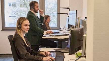 Plusieurs personnes au téléphone et face à un ordinateur