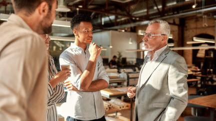 (crédit : Envato) Des hommes en train de discuter dans une entreprise