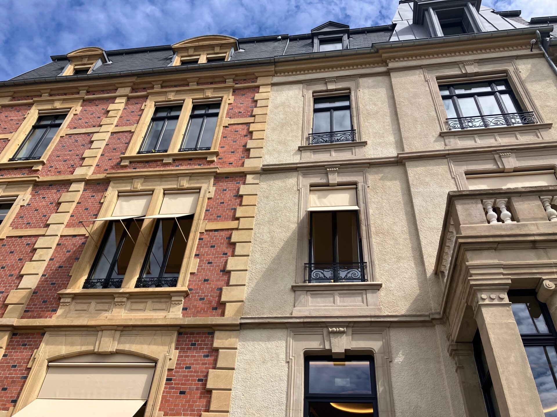 Les façades ont fait l'objet d'un nettoyage soigné avant l'application d'une patine d'harmonisation. Les chassis gris ont été choisis pour être en harmonie avec ceux du Casino voisin. (crédit : Catherine Moisy)