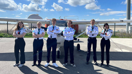 5 personnes devant un avion