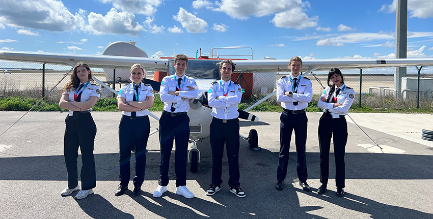 5 personnes devant un avion