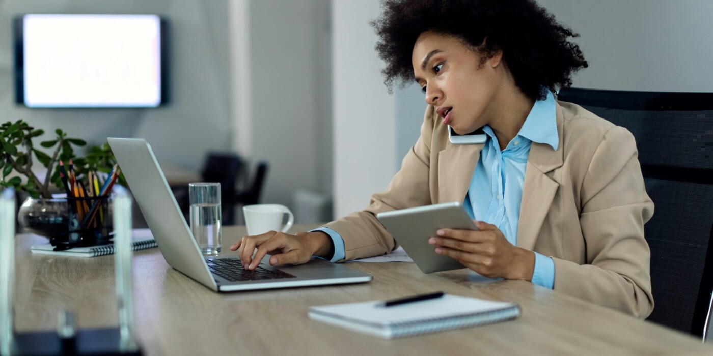 Jeune femme utilisant à la fois un ordinateur, une tablette et un smart phone
